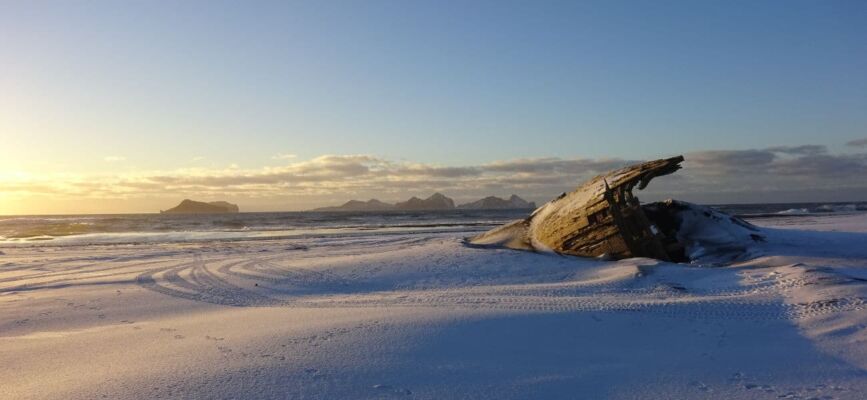 Gestrandetes Holzboot mit Blick auf Vestmannaeyjar